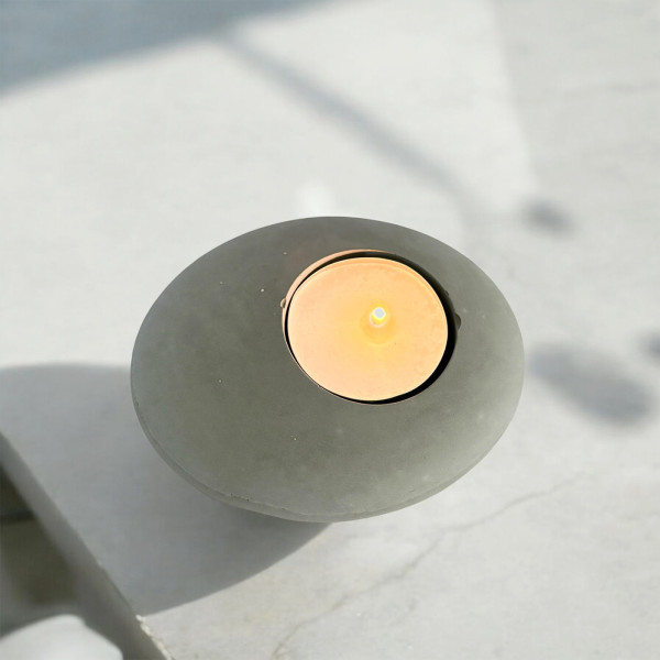 Grey concrete candle holder with lit candle, soft light for a cozy and soothing atmosphere